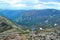 Rocks on mountain ridge, view of mountain lake in form of heart among snow ice glaciers, green mountain ranges overgrown with tree