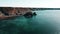 Rocks off the ocean coast line with turquoise water and dramatic cliffs Aerial view.