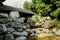 Rocks in pond outside aged Chinese gallery in sunny summer