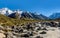 Rocks, river and snowy mountains in the background. Walking the