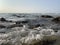 Rocks in the sea with a foaming wave