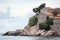 Rocks on shore and stone houses of Sveti Stefan island and hotel. Balkans, Adriatic sea, Montenegro, Europe