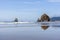 Rocks sticking out of the water on the Northwest coast of the Pacific Ocean reflected in mirror water