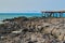 Rocks to the long pier with stairs and background the sea, Fuerteventura