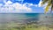 Rocks under Transparent Shallow Water Palm Branch Sky Clouds