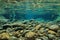 Rocks underwater on riverbed with clear freshwater