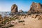 Rocks at Ursa beach, Sintra, Portugal. Epic sea stack towering at atlantic ocean coast lit by evening warm light