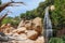 Rocks, Vegetation, Dry Trees and a Small Waterfall