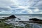 A rocky beach with bergs on Iceland in strong winds with powerful surf