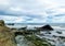 A rocky beach with bergs on Iceland in strong winds with powerful surf