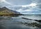 A rocky beach with bergs on Iceland in strong winds with powerful surf