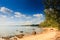 Rocky Beach Distant People Swim Hilly Island Sky Clouds