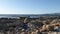 Rocky beach filled with plastic waste and trash. Ship and mountains on the background.