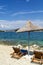 Rocky beach in Ksamil, the Ionian Sea with sunbeds and straw umbrellas. Blue and tourquse sea in background, nobody. Sunny