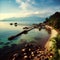 A rocky beach next to tropical greenery and the coast