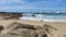 Rocky beach in Povoa de Varzim, Portugal on sunny day with blue sky and wispy white clouds