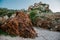 Rocky beach with red interesting geology and mediterranean vegetation, staircase, remote place