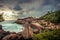 Rocky beach sea lagoon tropical scenery with palm trees and round stones with dramatic sunset sky vibrant colors in Sri Lanka