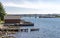 Rocky beach with a short wooden jetty and a small fishing boat near Hafrsfjord bridge