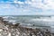 Rocky beach under blue sky with clouds in autumn