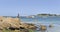 Rocky beach  view with boats and beacon  background