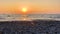 Rocky beach view of the evening sea horizon, with an orange sunset drive the sun before sunset.