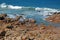 ROCKY BEACH WITH WHITE WAVES RUSHING IN