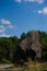 Rocky boulder on a hill in the forest, vertical