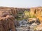 Rocky canyon with green bushes and trees in Palmwag Concession, Namibia, Southern Africa