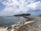 Rocky Caribbean coast under white cumulus clouds in tropical sky. Rock carved by the tropical waters of FWI. Magical environment