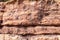 Rocky cliff face showing striations between the different layers of colored rocks, nature backdrop