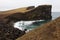 Rocky cliff with grass on Iceland Reykjanes peninsula volcanic stones shore coast line