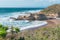 Rocky cliffs, sandy beach, and people enjoying beautiful sunny day. Montana de Oro State park, Los Osos, California Central Coast