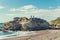 Rocky cliffs, sandy beach, and people enjoying beautiful sunny day. Montana de Oro State park, Los Osos, California Central Coast