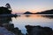 Rocky coast and calm water of Panormos bay after sunset, Skopelos island