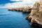 Rocky coast with the houses of Polignano a Mare and the blue sea