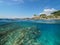 Rocky coast with a lighthouse and fish underwater, split view half above and below water surface