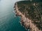 Rocky coast of the Lustica peninsula in Montenegro. Aerial drone view. Foamy waves hit the coast.