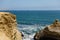 Rocky coast and a partial view of The Cathedral rock formation at the Paracas National Reserve