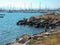 Rocky coast at the port basin of algeciras. Some fishing boats and sailboats in front of the container port in algeciras spain. In