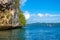 Rocky Coast with a Rainforest and Yacht in the Distance