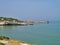 rocky coast with sandy coves, dry grass shrubs and trees