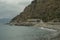 Rocky coast of the sea, tunnel in the mountains across the sea horizon, mountains and dramatic sky. Scenic landscape. Sestri Levan