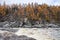 Rocky coast on the Siberian taiga river in the fall.