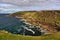 Rocky coast with steep cliffs, waves, sky, clouds