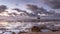 Rocky coastline beneath sunset sky with famous ARMAS shipwreck at low tide, Atlantic ocean, Morocco