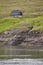 Rocky coastline faroese green landscape with traditional picturesque house