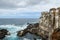 Rocky coastline, natural volcanic rock, foaming water and old building