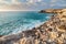 A rocky coastline next to a bay of crystal blue water