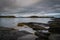 Rocky coastline in Oban bay on a stormy sunrise, Scotland